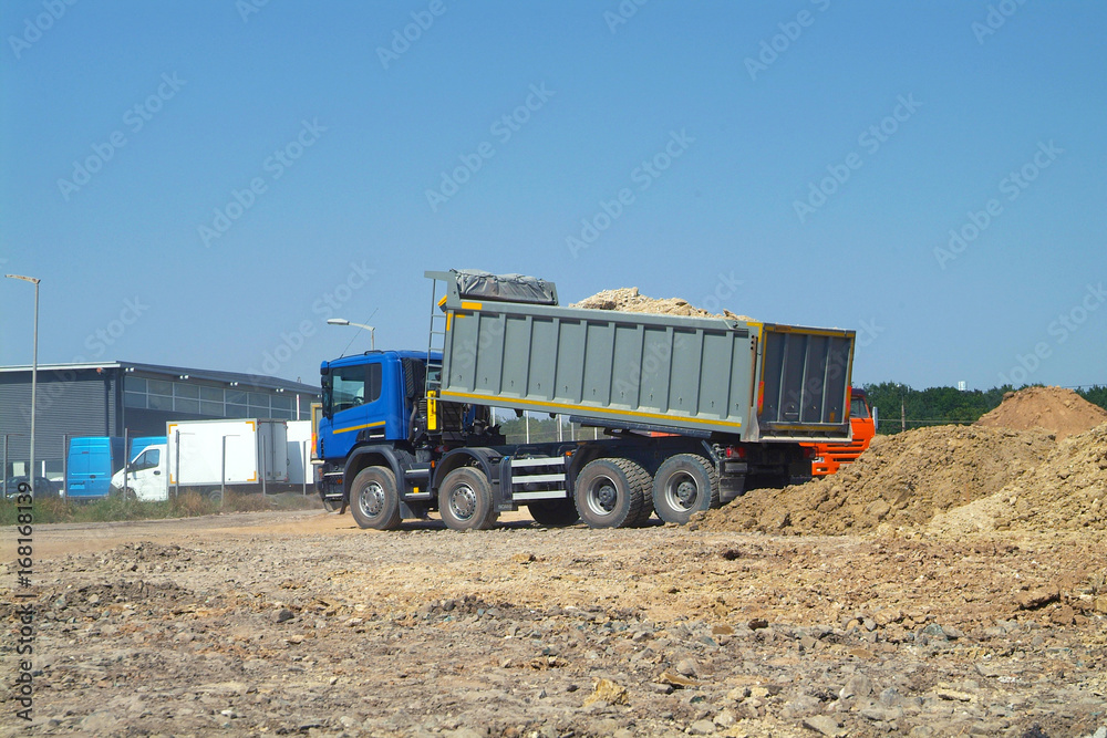 Dump truck unloading soil on construction site Dump truck unloading soil on construction site