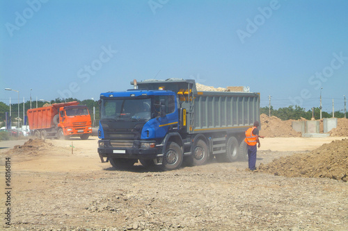 Fully loaded modern dump trucks preparing to on construction site
