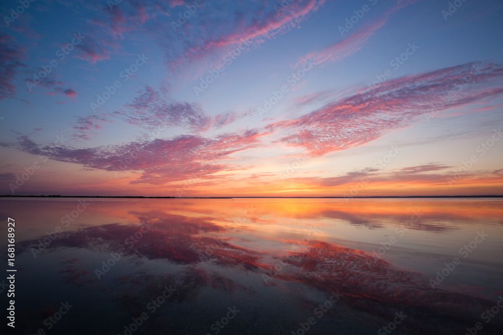Colorful beautiful cloudy sunset over ocean surface