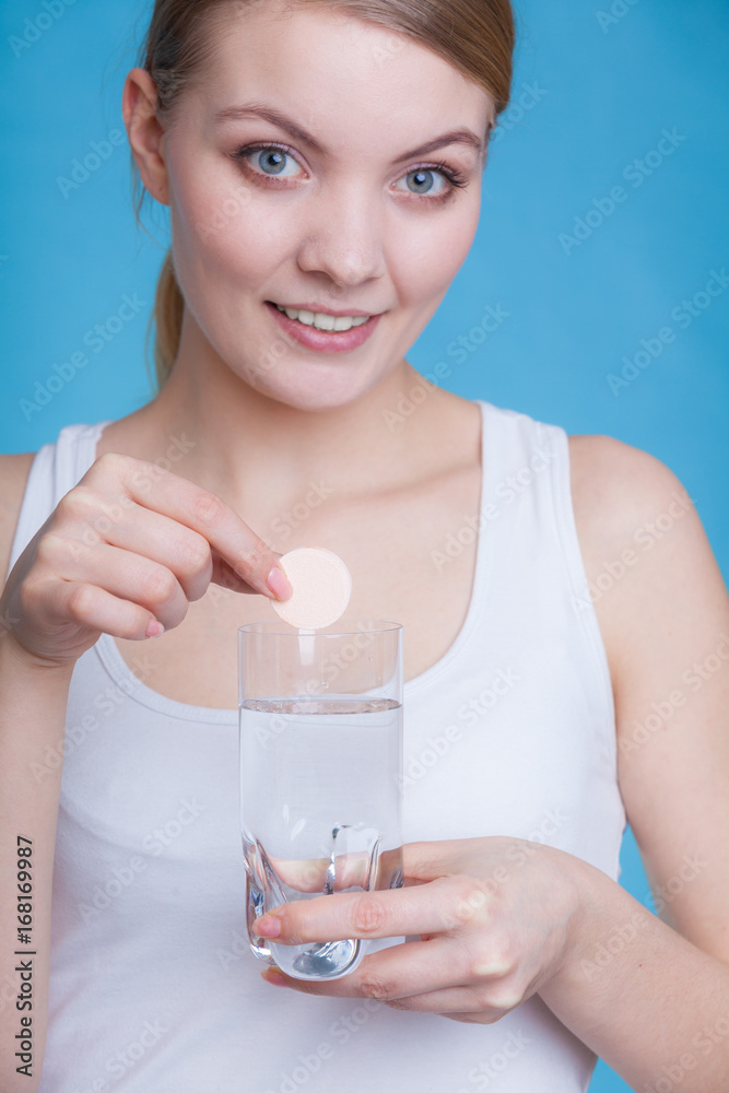 Woman holding glass with water and effervescent tablet Woman holding glass with water and effervescent tablet