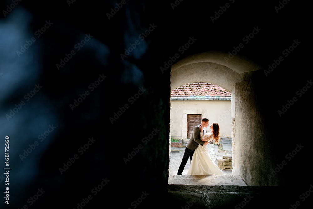 Look through the gates at wedding couple standing on the street Look through the gates at wedding couple standing on the street