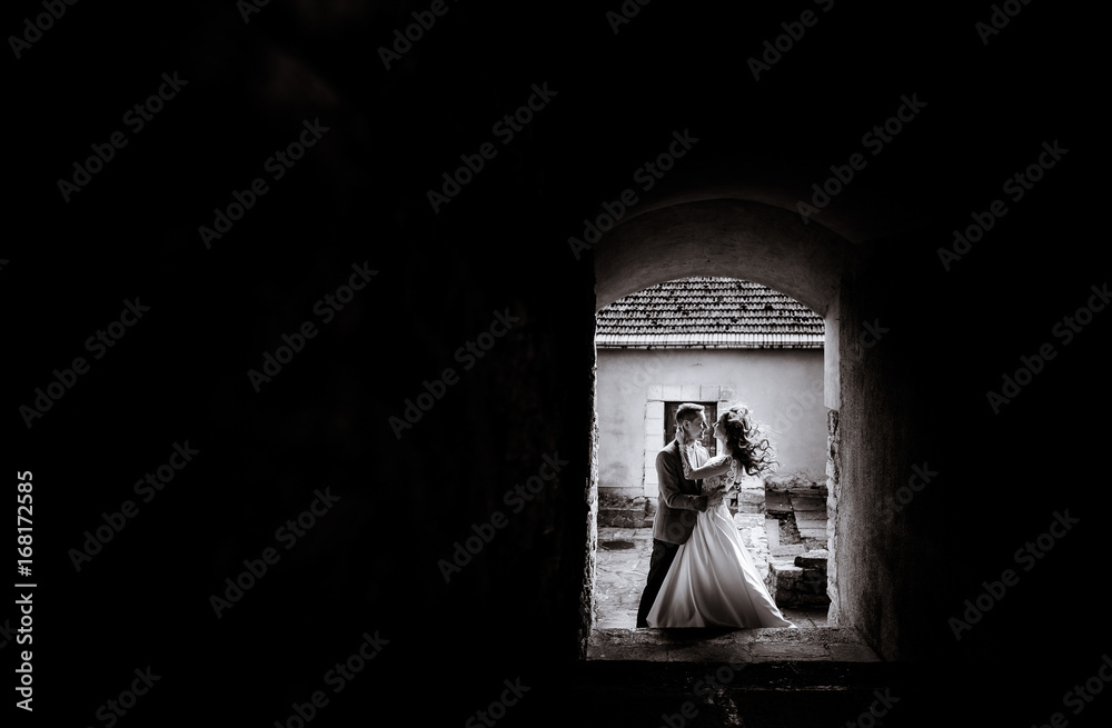 Look through the gates at wedding couple standing on the street