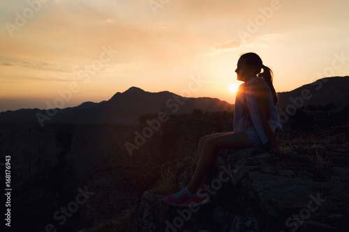 Girl looking at sunset on mountain