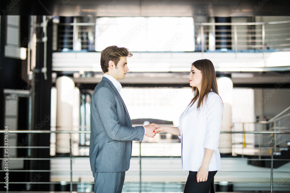 Business handshake - two businesspeople shaking hands to conclude deal or agreement. Business concept