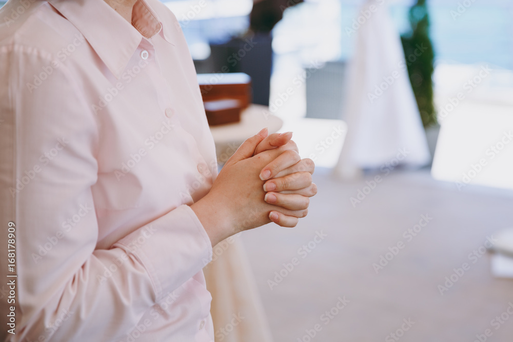 Folded fingers of a woman at a wedding