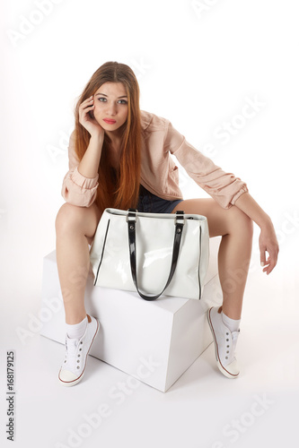 Stylish woman sitting with a bag in hands