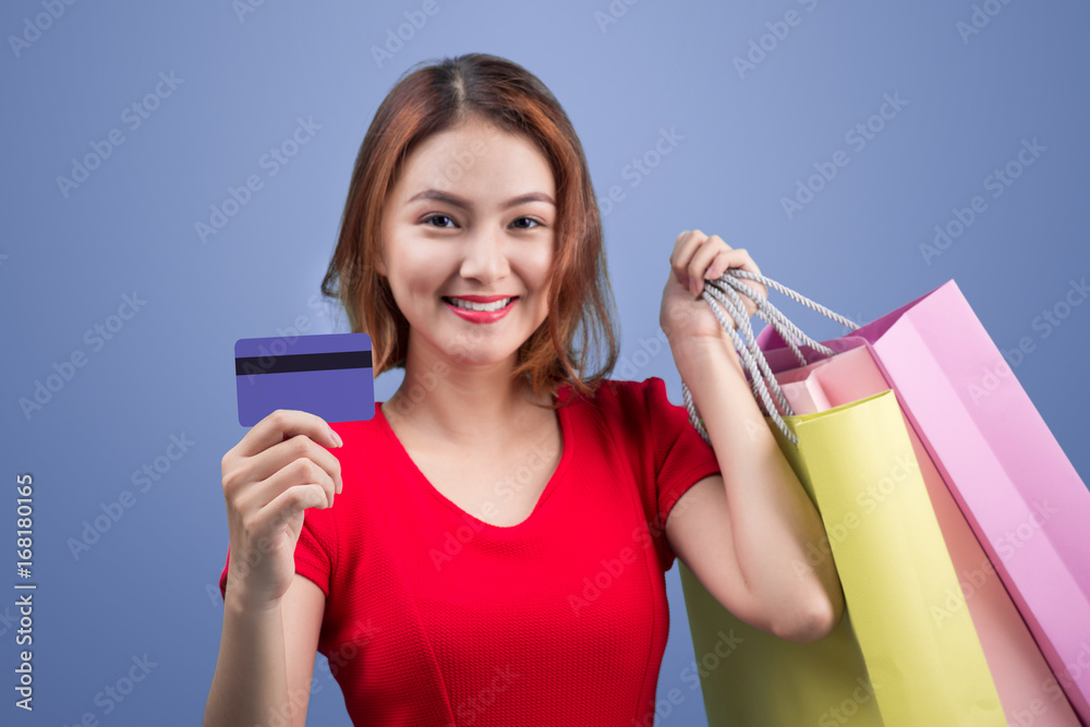 Φωτογραφία Santa asian woman holding shopping bags and credit card against violet