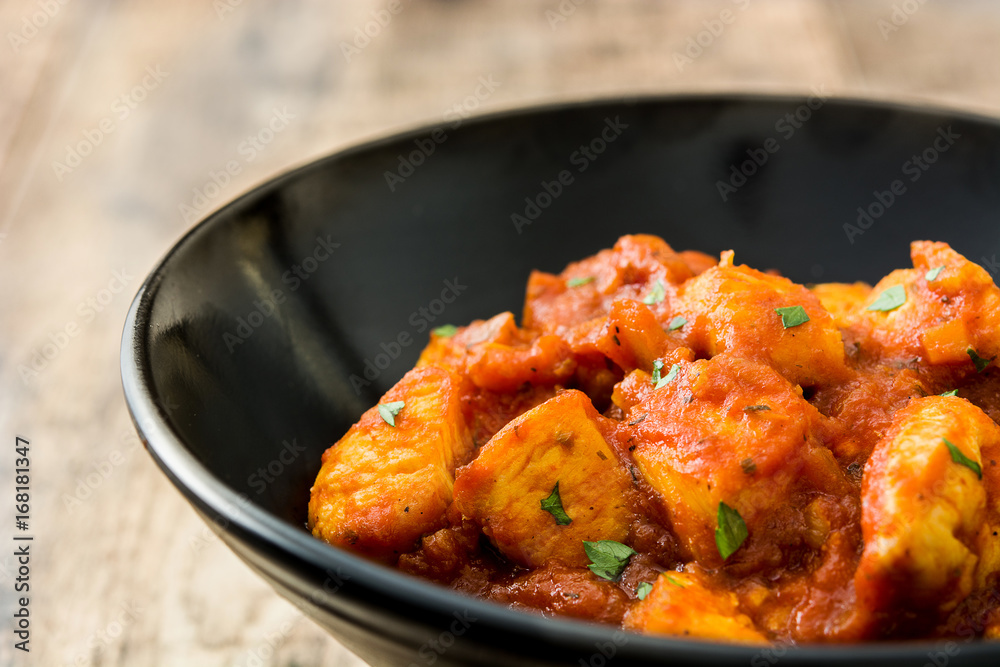 Chicken tikka masala in black bowl on wooden table
Chicken tikka masala in black bowl on wooden table