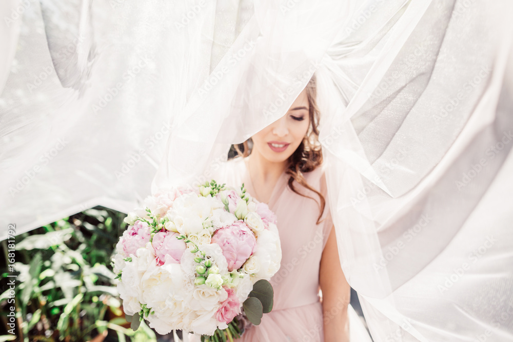 Naklejka premium Bride stands hidden under the veil