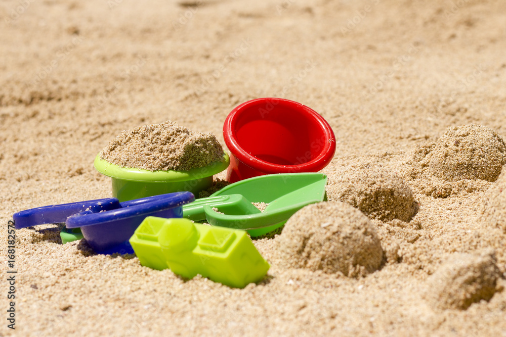 Plastic toys in sand / Set of colorful plastic toys in the beach Plastic toys in sand / Set of colorful plastic toys in the beach