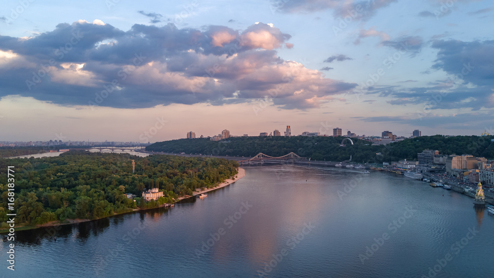 Aerial top view of Kiev city from above, hills, pedestrian Park bridge and Dnieper river on sunset, Ukraine
