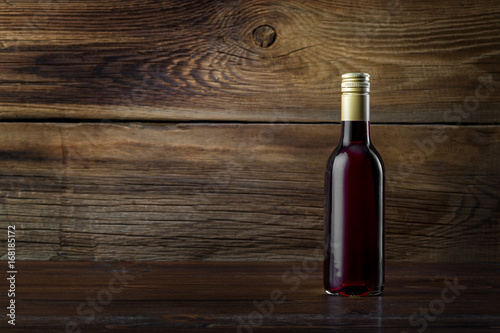 A bottle of red wine on a wooden background