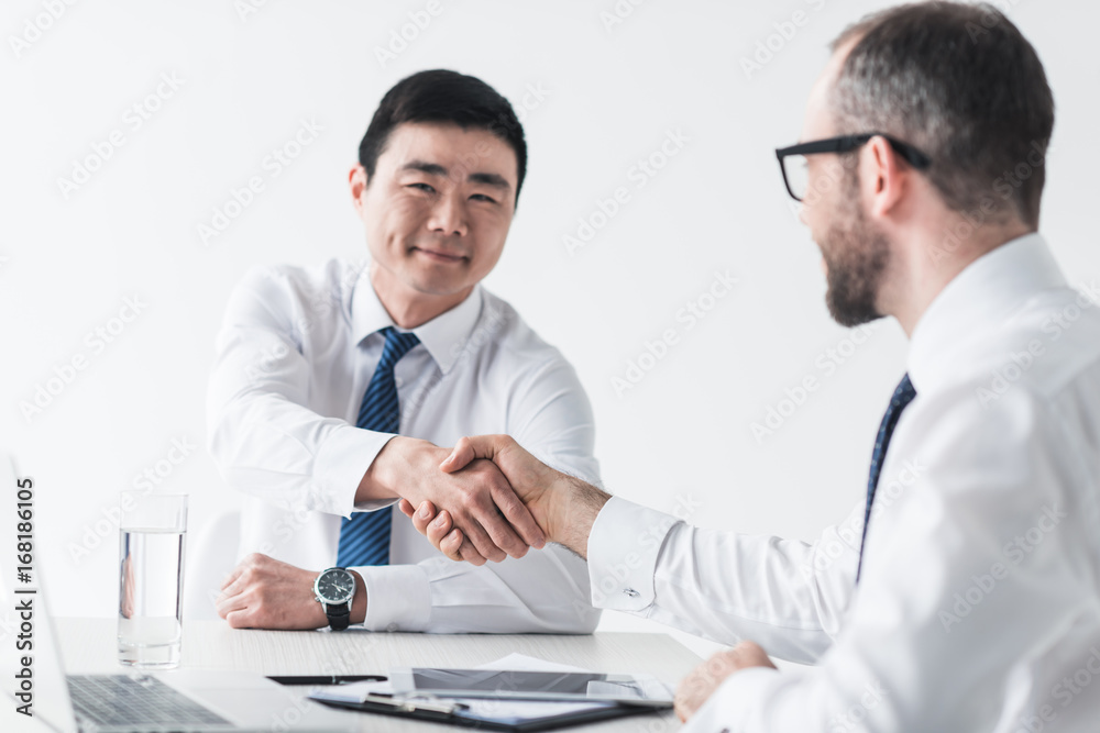 multicultural businessmen shaking hands on meeting
