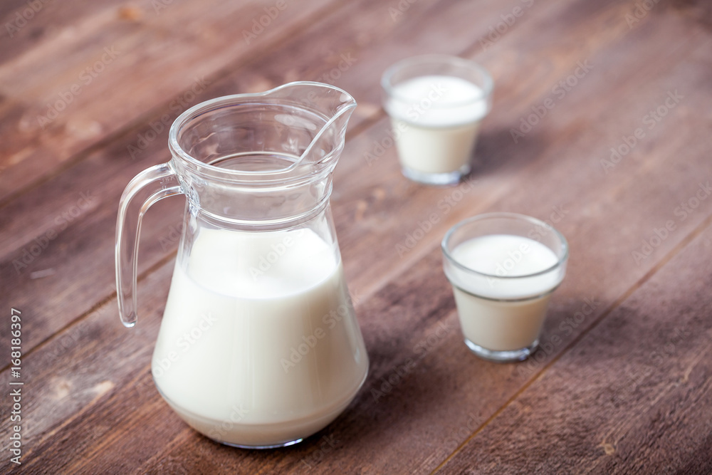 milk and glasses of milk on a wooden rustic table. milk and glasses of milk on a wooden rustic table.