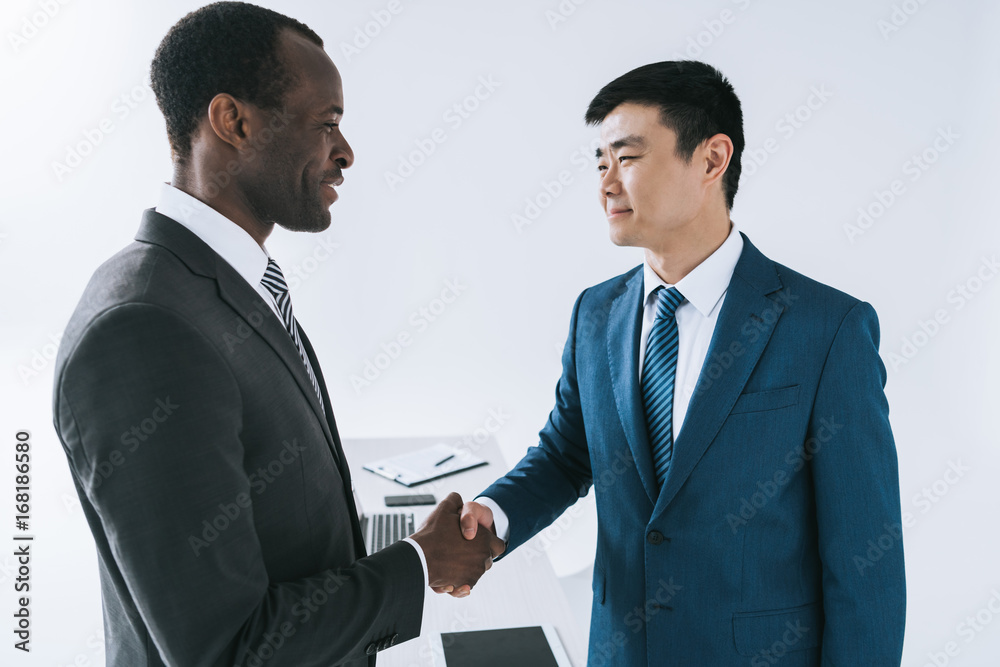 multiethnic businessmen shaking hands multiethnic businessmen shaking hands