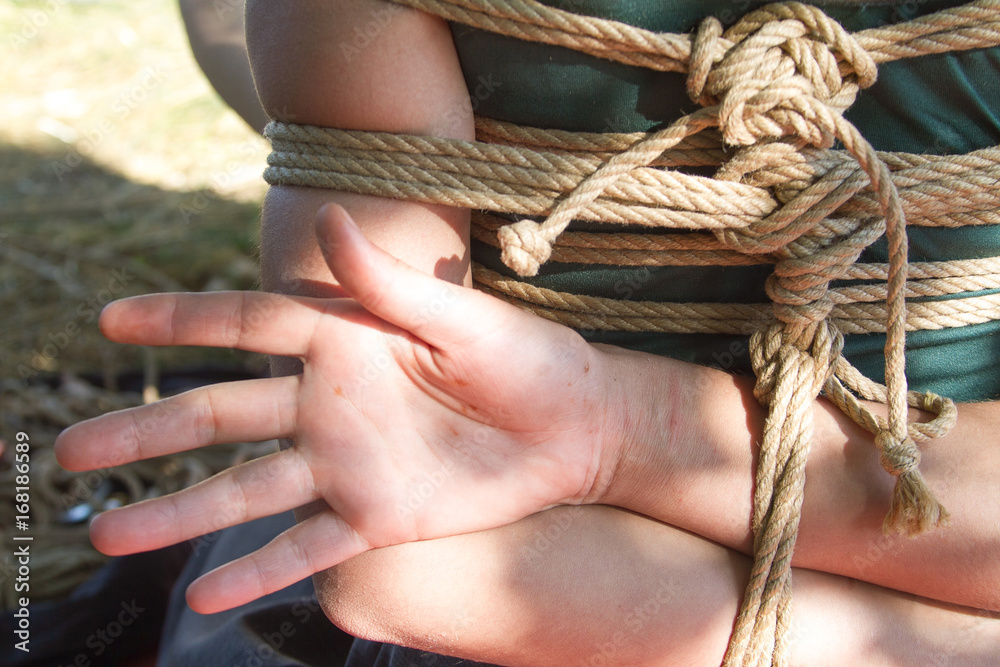 Shibari in nature in summer. Bound young girl.