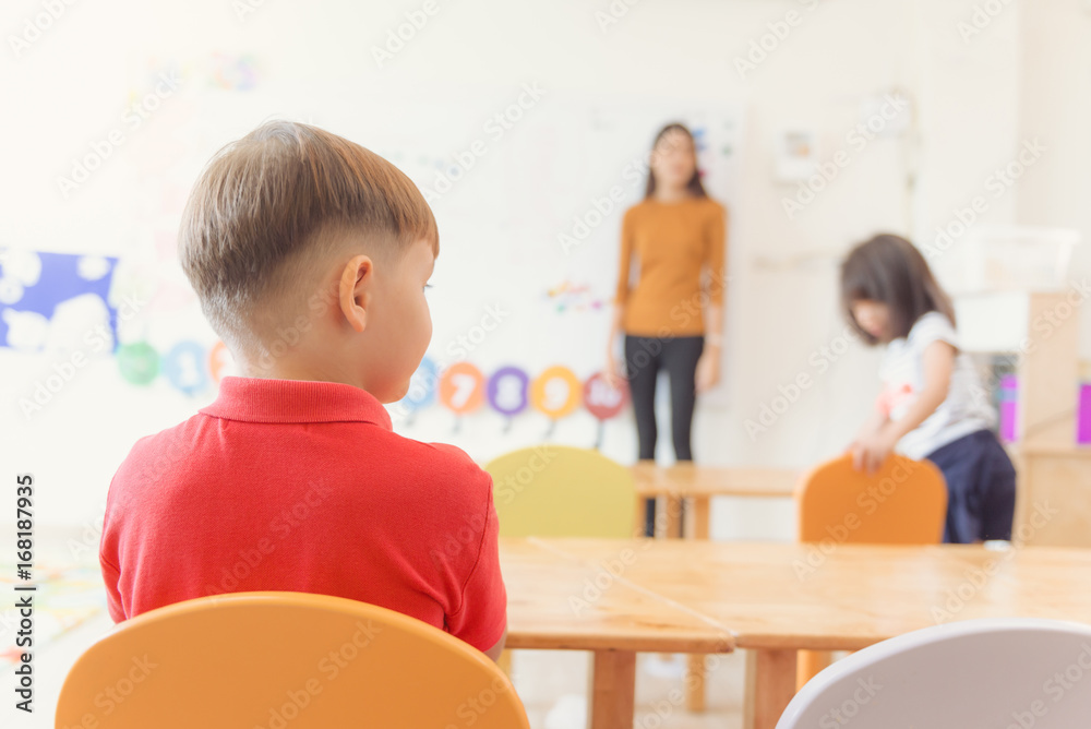 Education, elementary school, learning and people concept - group of school kids with teacher sitting in classroom. Vintage effect style pictures. Education, elementary school, learning and people concept - group of school kids with teacher sitting in classroom. Vintage effect style pictures.
