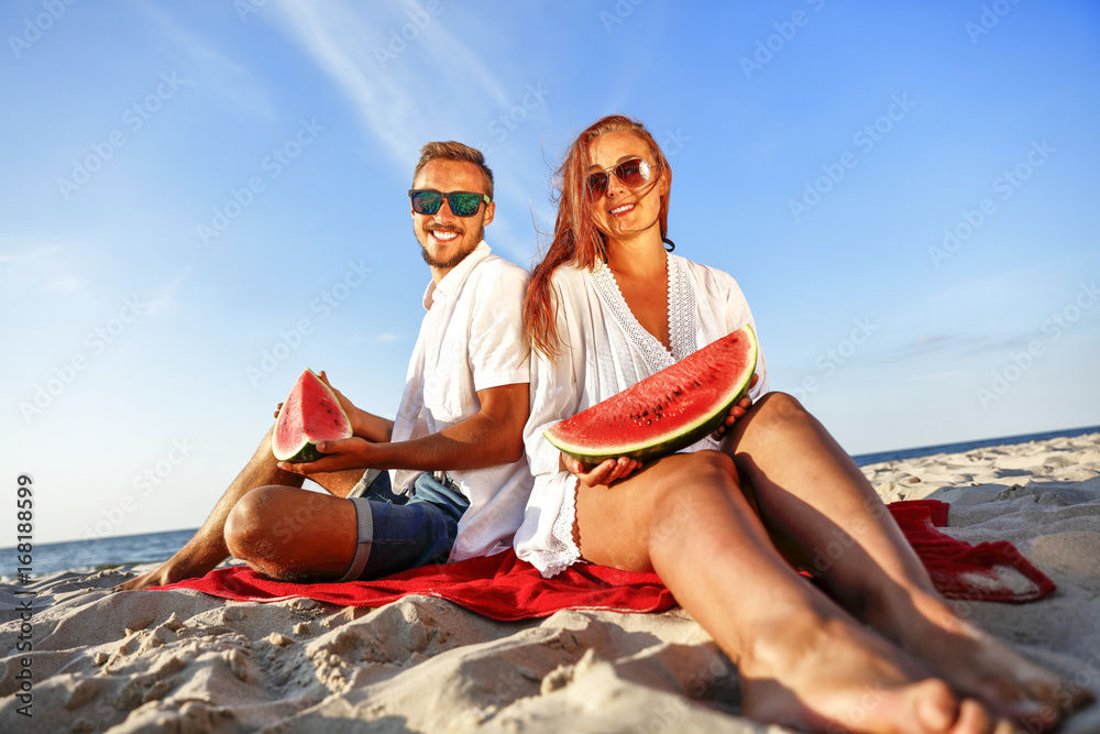 Fototapeta premium lovers on beach and water melon 