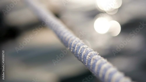 Detail of nautical rope with blurry water in the background
