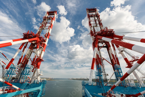 The red-white loading crane near the sea