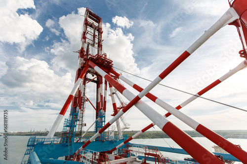 The red-white loading crane near the sea