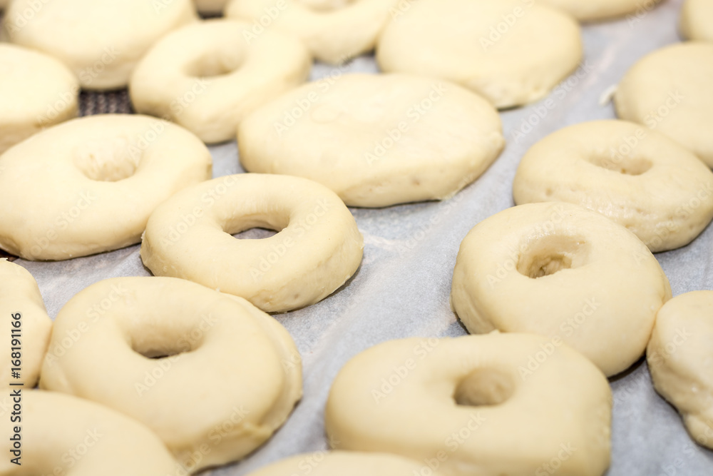 Closeup macro raw domestic homemade dough donuts prepared on the table ready for frying Closeup macro raw domestic homemade dough donuts prepared on the table ready for frying