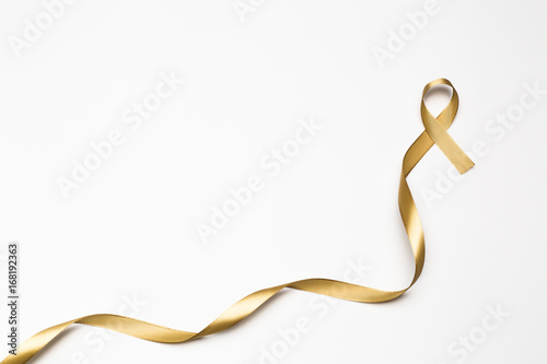 childhood ribbon, gold ribbon as symbol of childhood cancer awareness isolated on white background