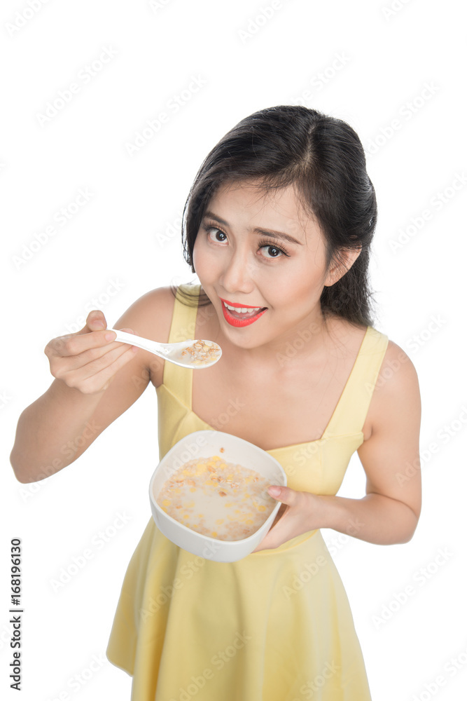 Asian woman eating bowl of cereal or muesli for breakfast Asian woman eating bowl of cereal or muesli for breakfast