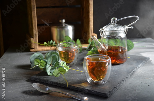 cup of tea in sunny morning. green fresh leaves on the table