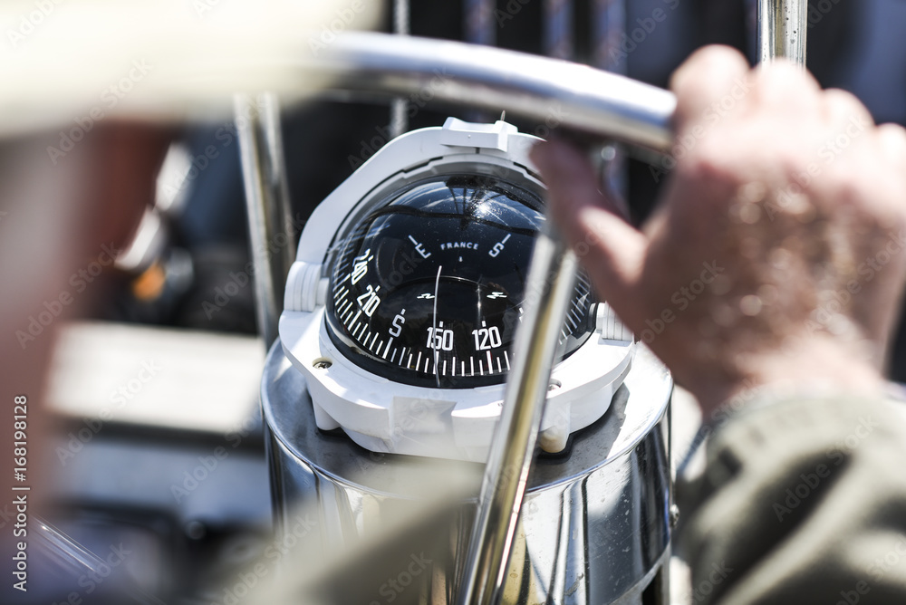 Obraz premium A compass, a view from above the steering wheel on a yacht.