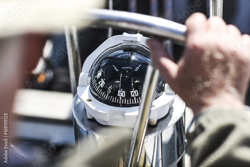 A compass, a view from above the steering wheel on a yacht.