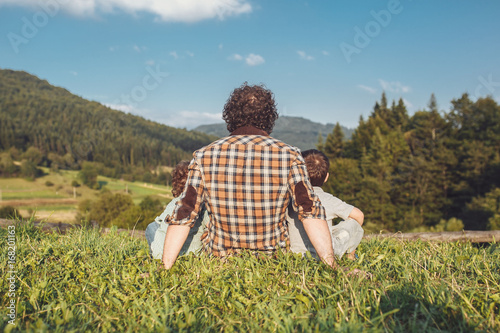 Happy father and son having fun and enjoying nature. Carpathian mountains. Sunny summer day. Happy family concept. photo