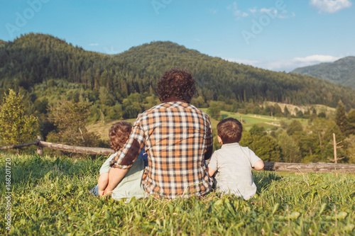 Happy father and son having fun and enjoying nature. Carpathian mountains. Sunny summer day. Happy family concept. photo