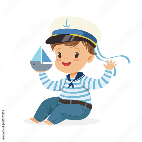 Cute smiling little boy character wearing a sailors costume sitting on the floor playing toy boat colorful vector Illustration