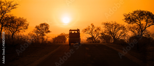 Safari vehicle at sunset