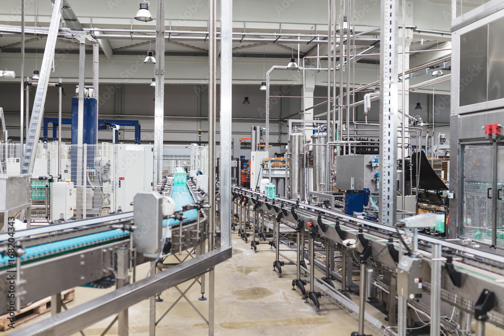 Industrial factory indoors and machinery. Robotic factory line for processing and bottling of pure spring water into canisters and bottles. Selective focus. Short depth of field. Industrial factory indoors and machinery. Robotic factory line for processing and bottling of pure spring water into canisters and bottles. Selective focus. Short depth of field.