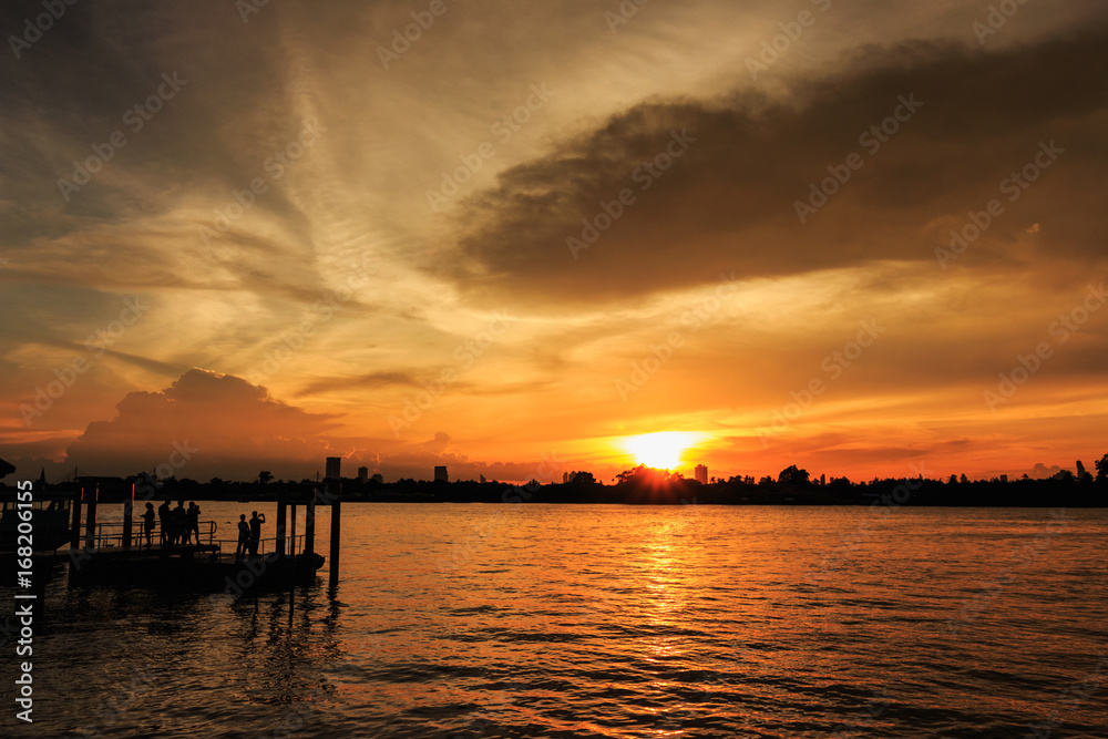 Sunset  at city of Bangkok near riverside with  people  silhouette