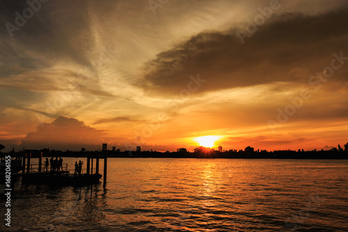 Sunset  at city of Bangkok near riverside with  people  silhouette