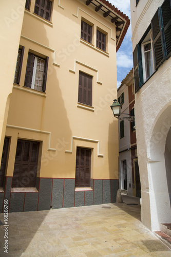 Narrow street on an old building neighbourhood in Menorca  Spain