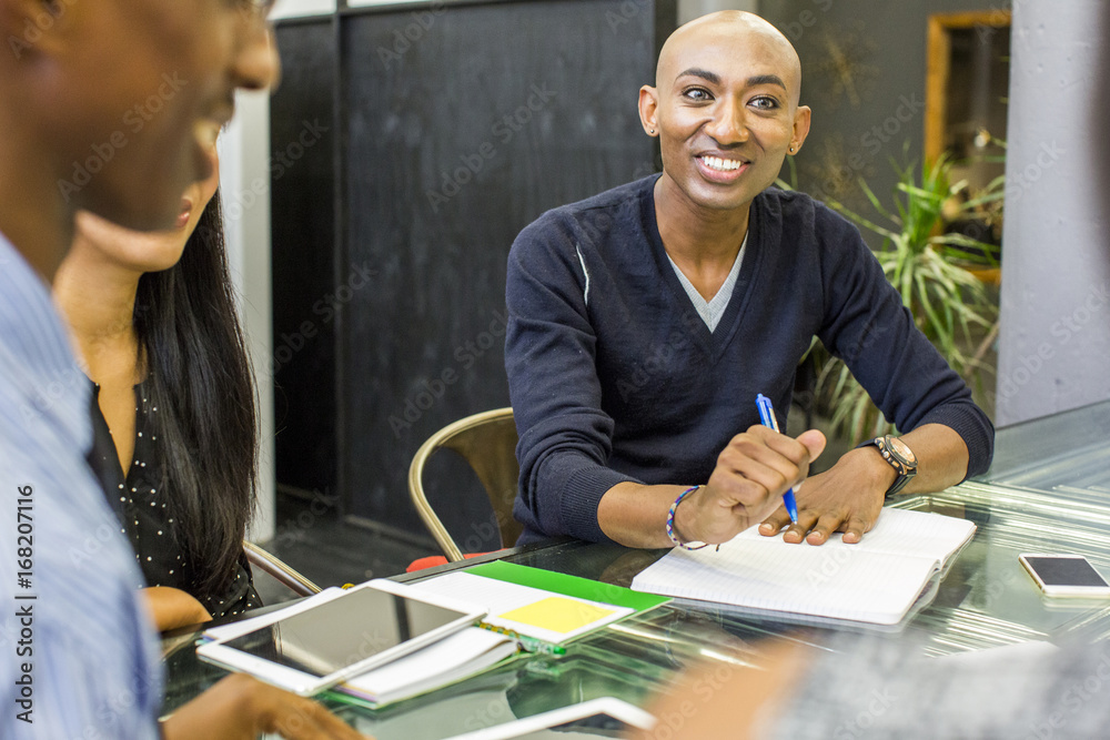 © Adam Hester/Blend Images - Smiling man with notebook in meeting © Adam Hester/Blend Images - Smiling man with notebook in meeting
