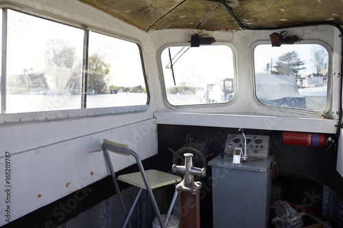 Cabin Of River Boat With Wheel And Controls Moored In Marina photo