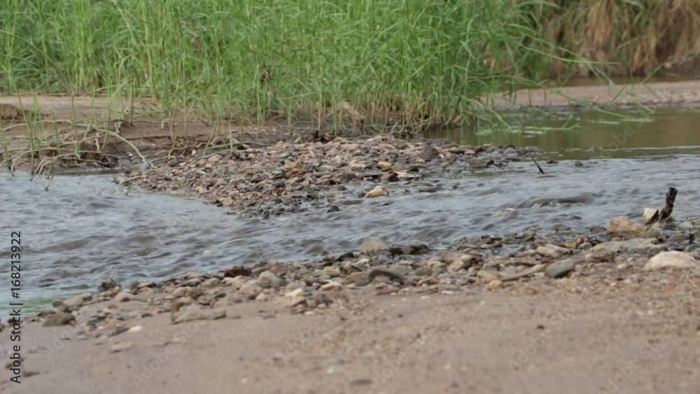 The stream flows through the rocks. The stream flows through the rocks.