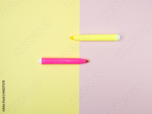 pink and yellow magic pen on split-half yellow and pink background, minimal concept and similarities differences photo