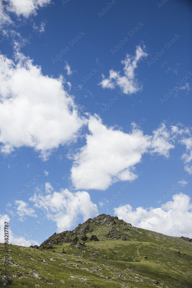Green hills mountains landscape. Blue sky with clouds. Altai, Russia Green hills mountains landscape. Blue sky with clouds. Altai, Russia