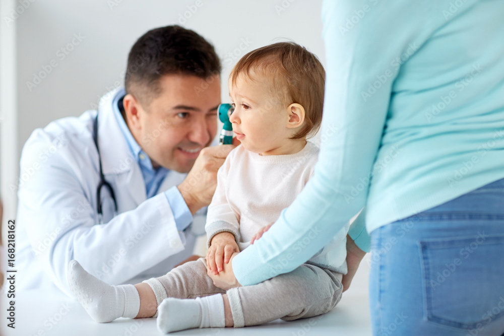 doctor with otoscope checking baby ear at clinic doctor with otoscope checking baby ear at clinic