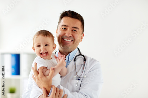 happy doctor or pediatrician with baby at clinic photo