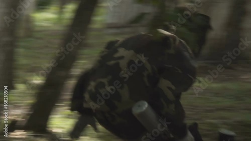 People play paintball in the woods