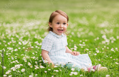 happy baby girl on green summer field