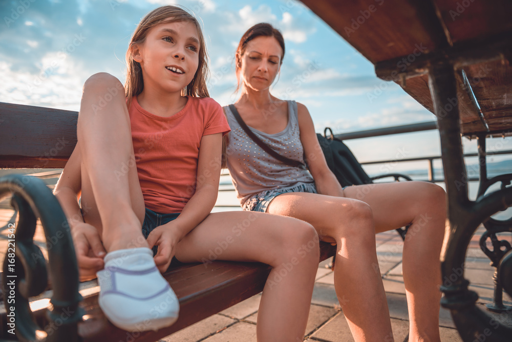 Mother and daughter sitting on the bench Mother and daughter sitting on the bench
