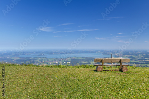 Bench at lookout on Summit of Mount Hochfelln overlook at Lake Chiemsee on a sunny summer day at early Morning photo